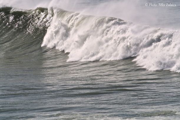 En lo alto de la ola, bajo la cresta, se ve la pierna del surfista. Calcula los metros.